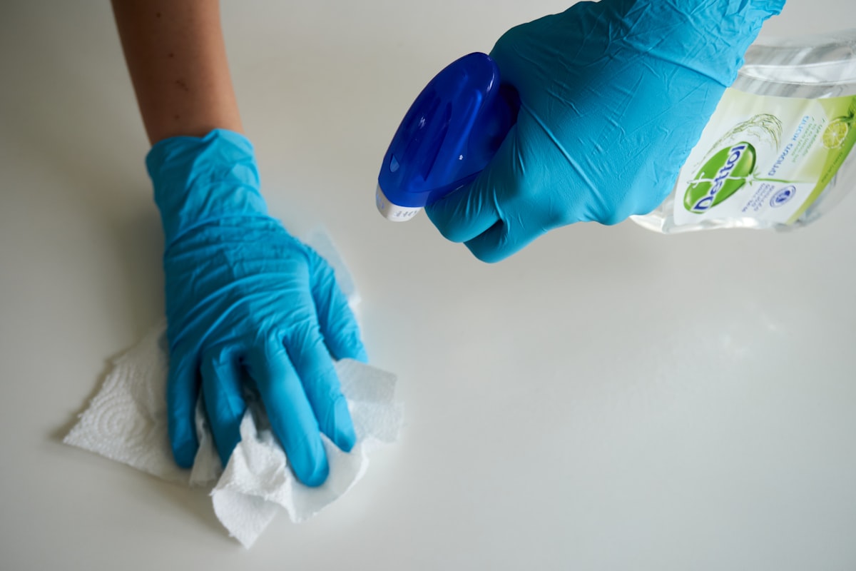 Professional cleaner wearing blue gloves during a deep clean