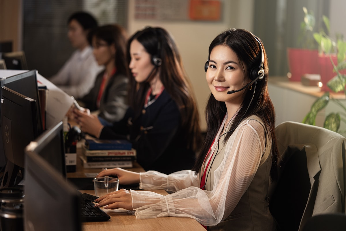 Helpdesk operative with headset at a computer workstation
